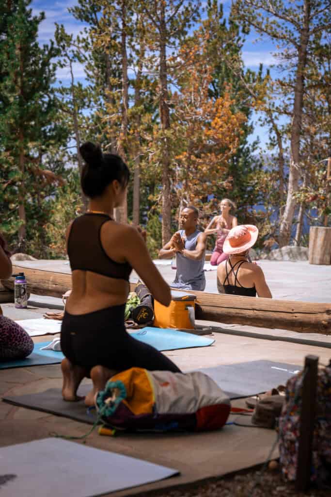 yoga instructor and students at the tahoe yoga festival with pine trees in the background